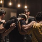 Believers gathered in prayer and unity showing the importance of Christian community and fellowship for spiritual growth and encouragement.